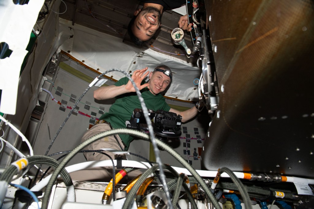 Expedition 69 Flight Engineers (from top) Sultan Alneyadi of UAE (United Arab Emirates) and Woody Hoburg of NASA are pictured inside the Tranquility module working on life support maintenance tasks aboard the International Space Station.