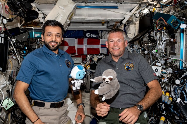 Expedition 69 Flight Engineers Sultan Alneyadi of UAE (United Arab Emirates) and Andreas Mogensen of ESA (European Space Agency) pose for a portrait together aboard the International Space Station's Columbus laboratory module. Alneyadi holds a stuffed doll, Suhail, he carried with him aboard the SpaceX Dragon Endeavour spacecraft. Mogensen shows off a plush three-toed sloth doll he carried aboard the SpaceX Dragon Endurance during his ride to space. The dolls are not just mascots but also gravity indicators to show they have reached space.