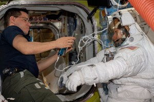 NASA astronaut Frank Rubio (left) assists NASA astronaut Woody Hoburg during a fit check of his spacesuit inside the International Space Station's Quest airlock.