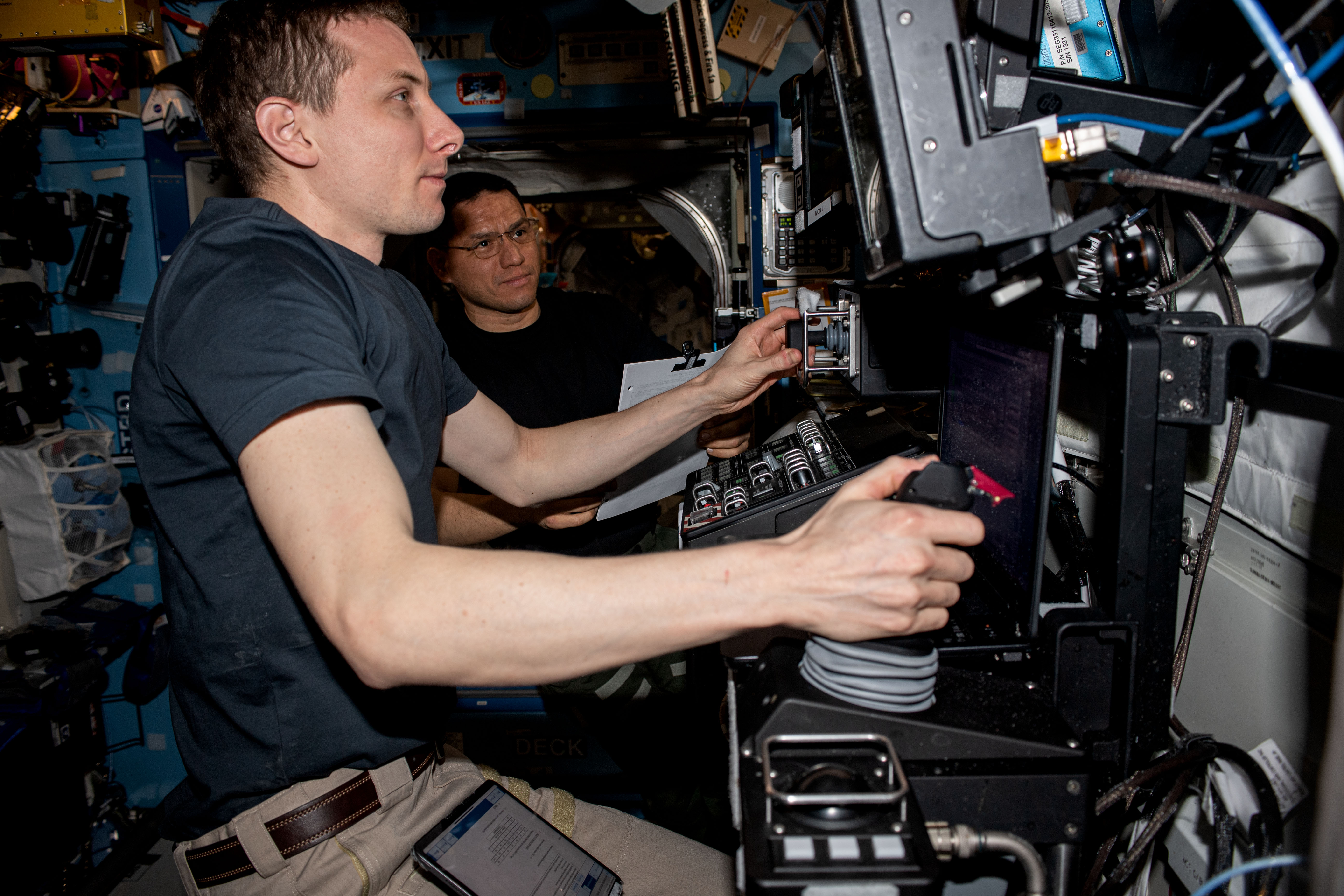 Expedition 69 Flight Engineers (from left) Woody Hoburg and Frank Rubio, both from NASA, are pictured practicing on the International Space Station's robotics workstation to capture Northrop Grumman's Cygnus cargo craft with the Canadarm2 robotic arm.