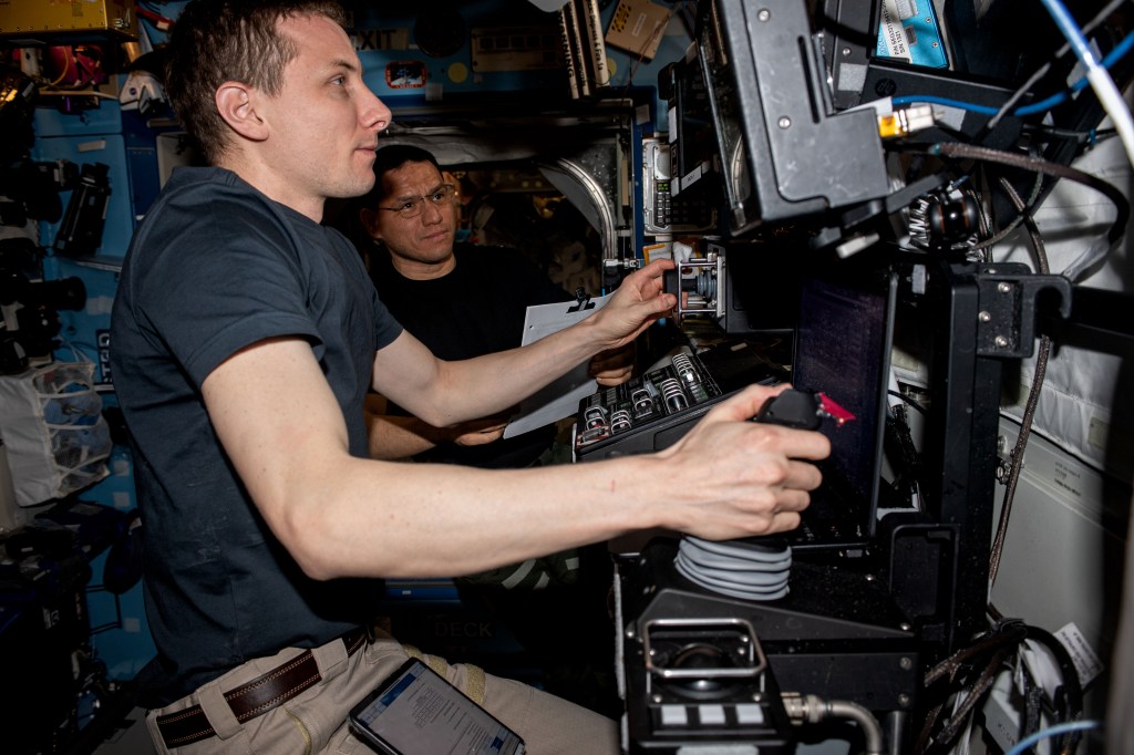 Expedition 69 Flight Engineers (from left) Woody Hoburg and Frank Rubio, both from NASA, are pictured practicing on the International Space Station's robotics workstation to capture Northrop Grumman's Cygnus cargo craft with the Canadarm2 robotic arm.