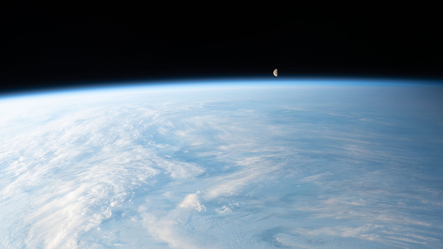 The waning gibbous Moon is pictured just above Earth's horizon in this photograph from the station as it orbited 262 miles above a cloudy central Asia.