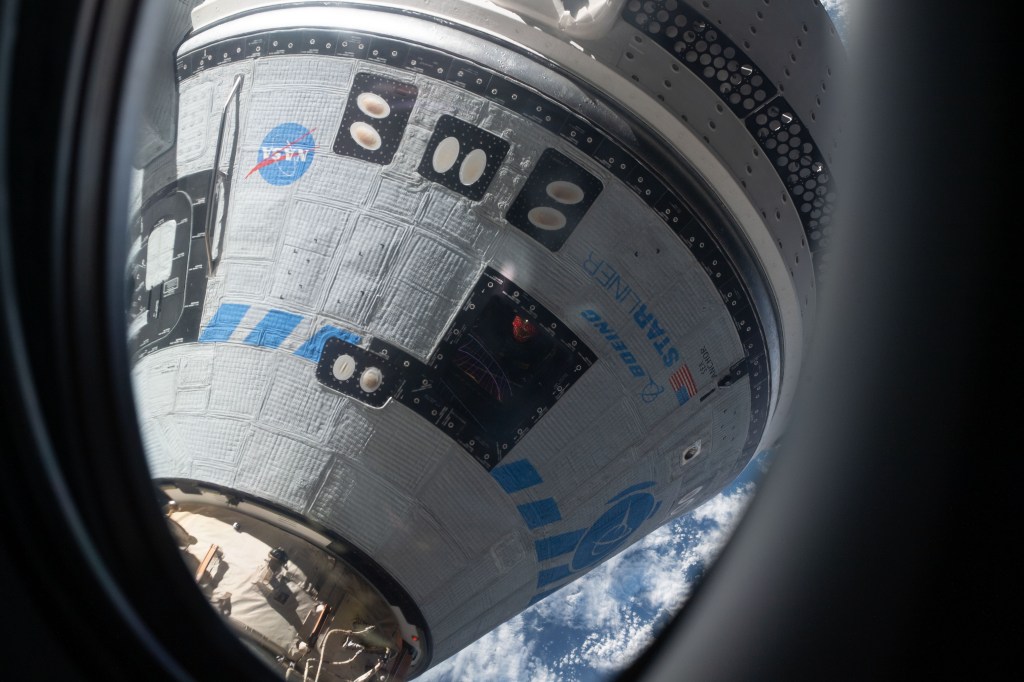 This view from a window on the SpaceX Crew Dragon Freedom crew ship shows Boeing's CST-100 Starliner crew ship after it had docked to the Harmony module's forward port on the International Space Station for the company's Orbital Flight Test-2 mission.
