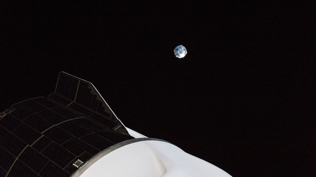 Boeing's CST-100 Starliner crew ship is pictured maneuvering away from the International Space Station after undocking from the Harmony module's forward port. In the foreground, is the aft end of the SpaceX Dragon Freedom crew ship that delivered the Crew-4 astronauts to the orbiting lab.