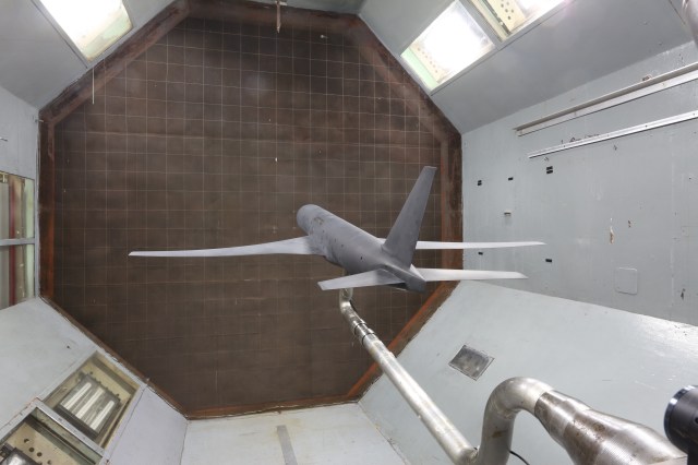 A scale model of a typical airliner is seen mounted on a stand inside a NASA wind tunnel