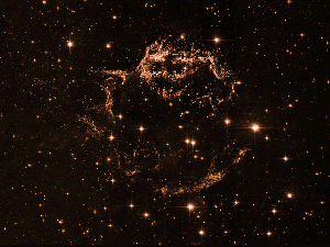 In the primary image, the spherical cloud resembles a hazy ball of turquoise and neon blue lightning, marbled with veins of gold. The blues represent data from the Chandra Observatory, the turquoise is from NASA's Imaging X-ray Polarimetry Explorer (called IXPE), and the gold is courtesy of the Hubble Telescope.