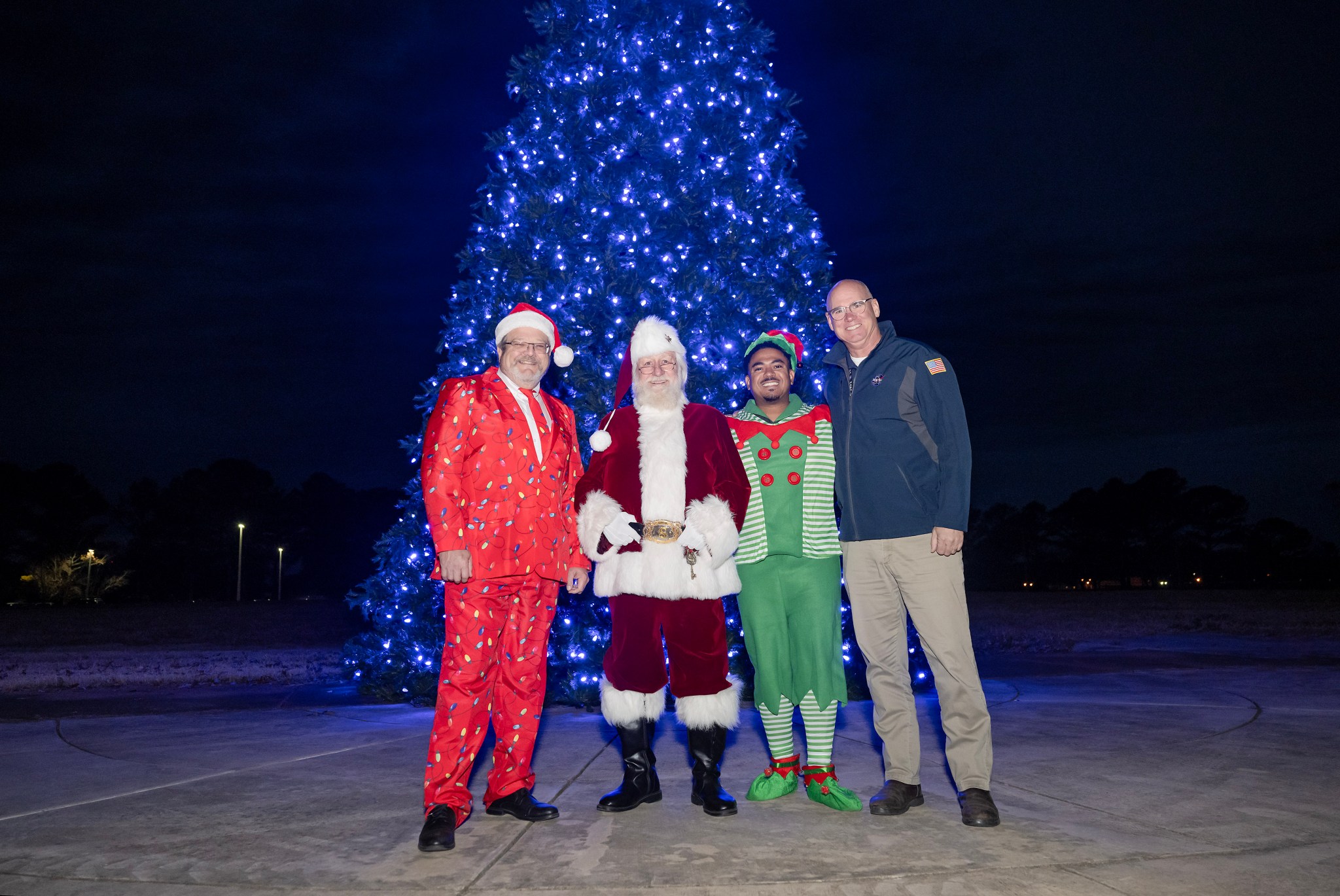 From left, Robert Champion, director of the Office of Center Operations at Marshall, Santa Claus, Lance D. Davis, Marshall news chief who is dressed as an elf, and Bill Marks, deputy director of Center Operations, smile for a photo after the tree-lighting ceremony.
