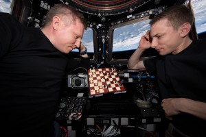 From left, Expedition 69 Commander Sergey Prokopyev of Roscosmos and Flight Engineer Woody Hoburg of NASA each contemplate their next move during an orbital game of chess inside the International Space Station's cupola. The orbital lab was soaring 259 miles above the Colombia-Venezuela border at the time of this photograph.