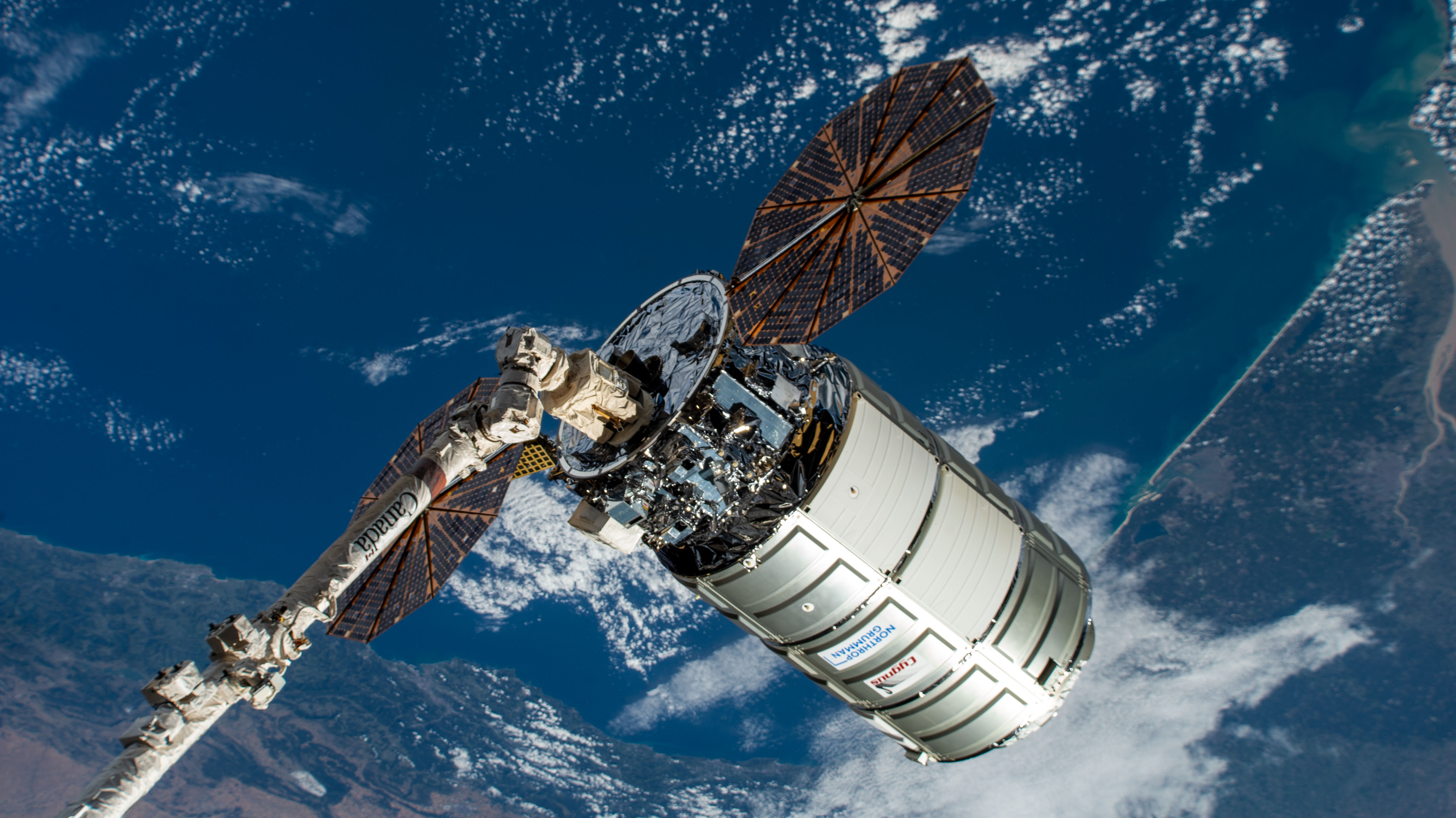 Northrop Grumman's Cygnus space freighter is positioned away from the International Space Station in the grips of the Canadarm2 robotic arm prior to its release ending a four-month stay attached to the orbiting lab's Unity module.