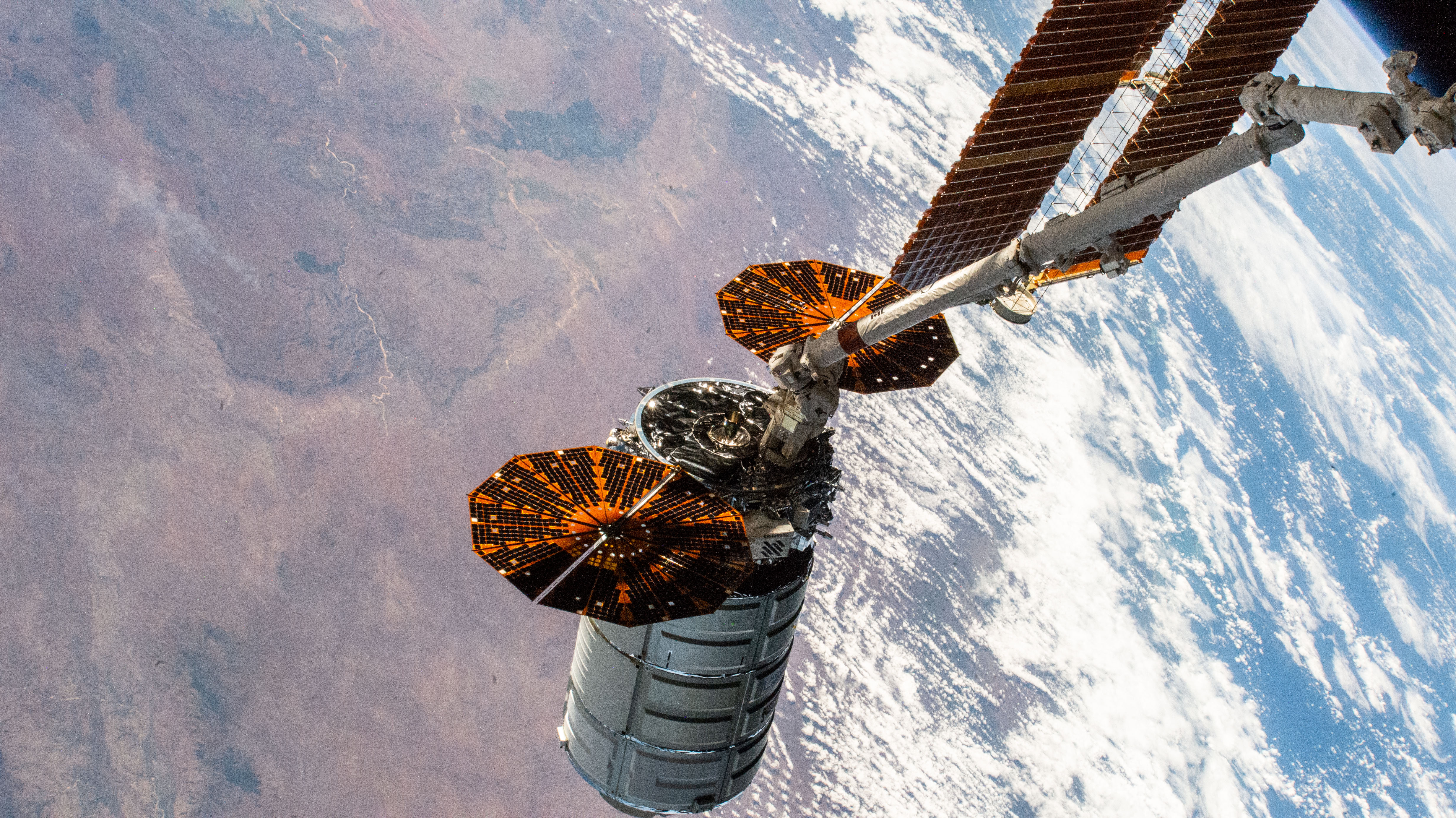 Northrop Grumman's Cygnus space freighter is positioned away from the International Space Station in the grips of the Canadarm2 robotic arm prior to its release ending a four-month stay attached to the orbiting lab's Unity module. The orbiting complex was flying 263 miles above Madagascar at the time of this photograph.