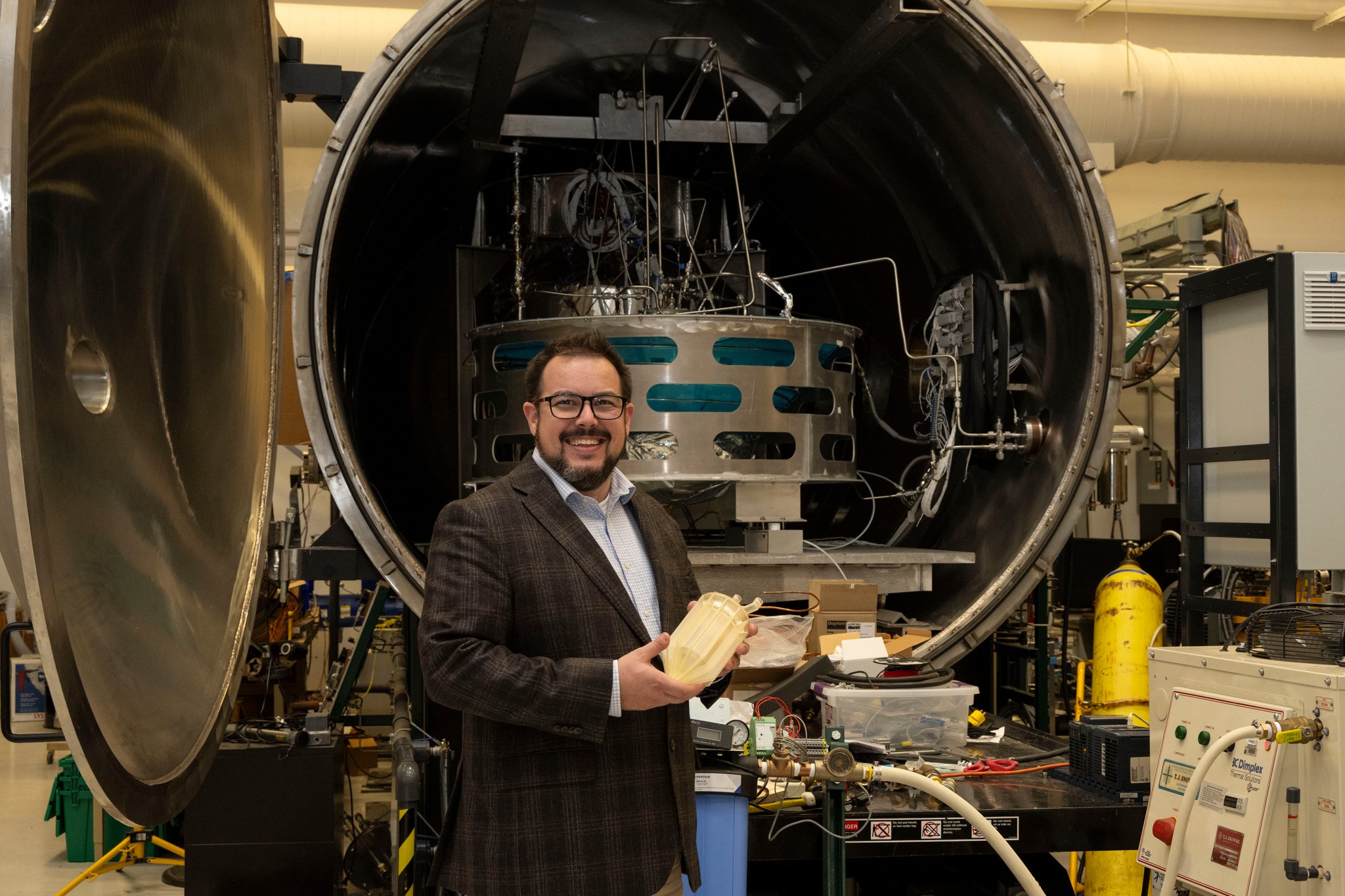 Jason Adam, manager for the CFM Portfolio Project at NASA’s Marshall Space Flight Center, holds a full-size resin model of a Thermodynamic Vent System Injector while standing in front of an Exploration Systems Test Facility within the CFM Laboratory in Building 4205.