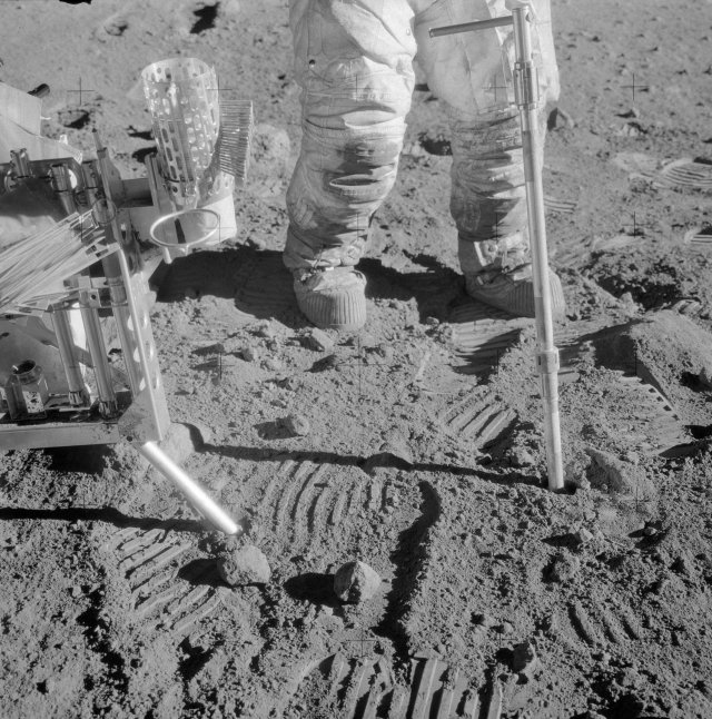 An Apollo astronaut drives a geology tool called a drive tube into the surface of the Moon to collect lunar soil at an Apollo 12 site. Geologists call this a core sample.