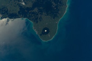 Egmont National Park, nearing the west coast of the North Island of New Zealand, is pictured as the International Space Station orbited roughly 270 miles above. The snow-capped stratovolcano, Mount Taranaki, sits at roughly 8,300 feet (~ 2,500 meters), surrounded by lush forests that provide strong visibility from low-Earth orbit.