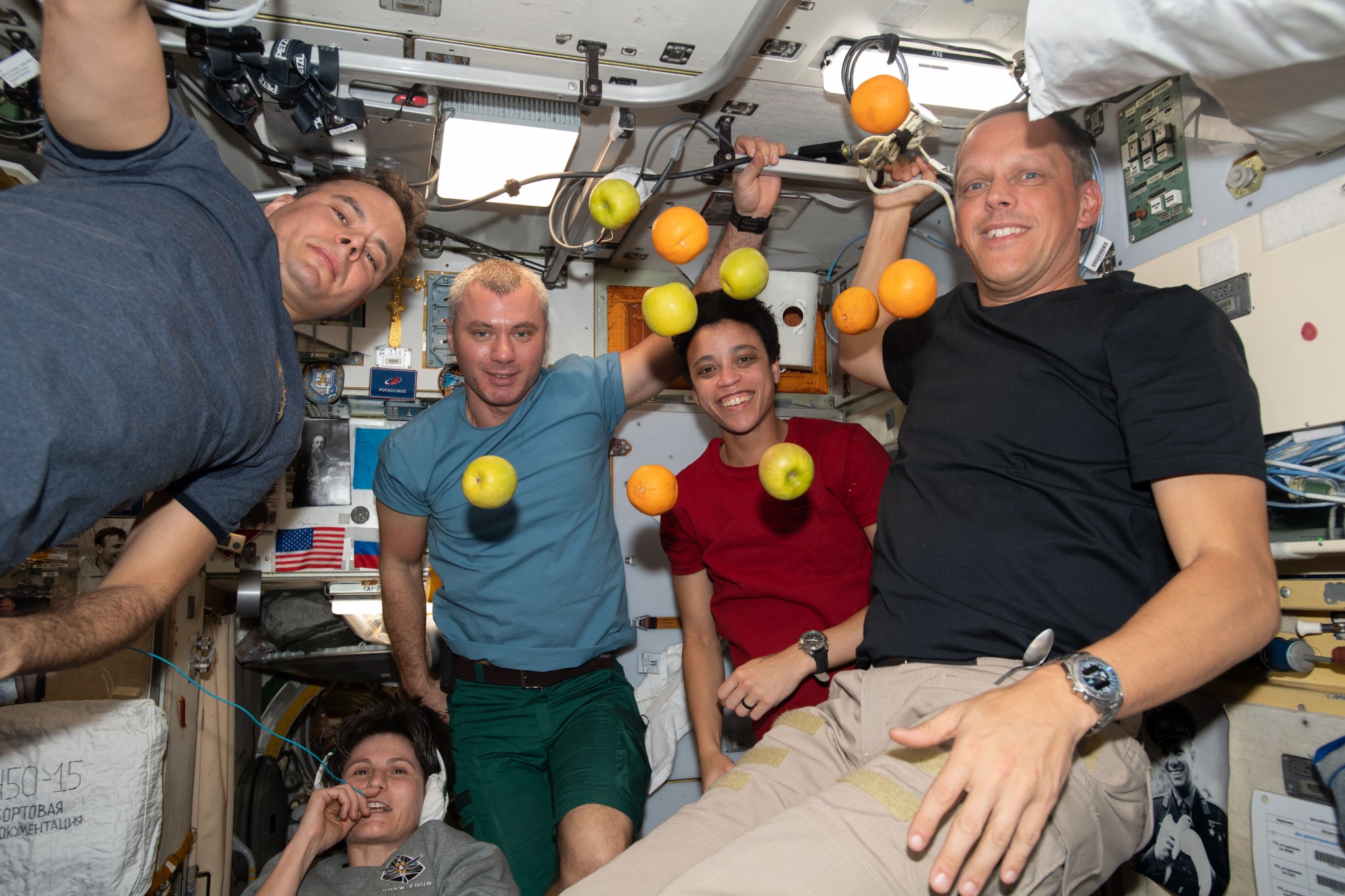 Expedition 67 crew members pose with fresh fruit flying weightlessly in microgravity delivered recently aboard the Progress 81 (81P) cargo craft. The 81P docked to the Zvezda service module's rear port aboard the International Space Station after a three-and-half-hour trip that began with a launch from the Baikonur Cosmodrome in Kazakhstan. Pictured from left are, Roscosmos Flight Engineer Sergey Korsakov; ESA (European Space Agency) Flight Engineer Samantha Cristofretti; Roscosmos Flight Engineer Denis Matveev; and NASA Flight Engineers Jessica Watkins and Bob Hines.