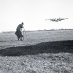 Photographer filming low flying aircraft.