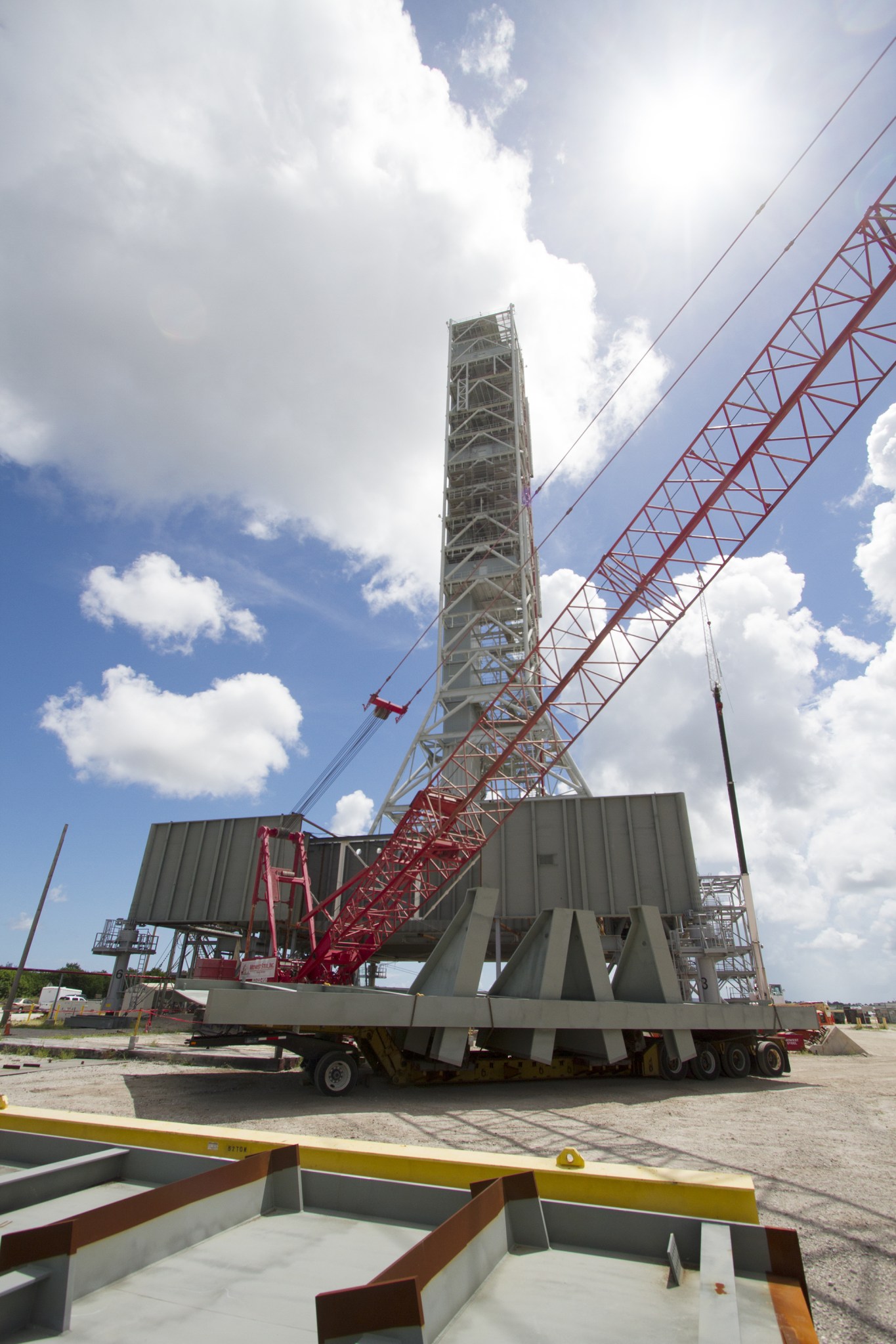 Modifications continue on the Mobile Launcher, or ML, at the Mobile Launcher Park Site at NASA's Kennedy Space Center in Florida. A crane is in place to lift a new steel beam for installation on the ML structure. The ML is being modified and strengthened to carry NASA's Space Launch System rocket and Orion spacecraft to Launch Pad 39B for its first uncrewed mission, Exploration Mission-1.