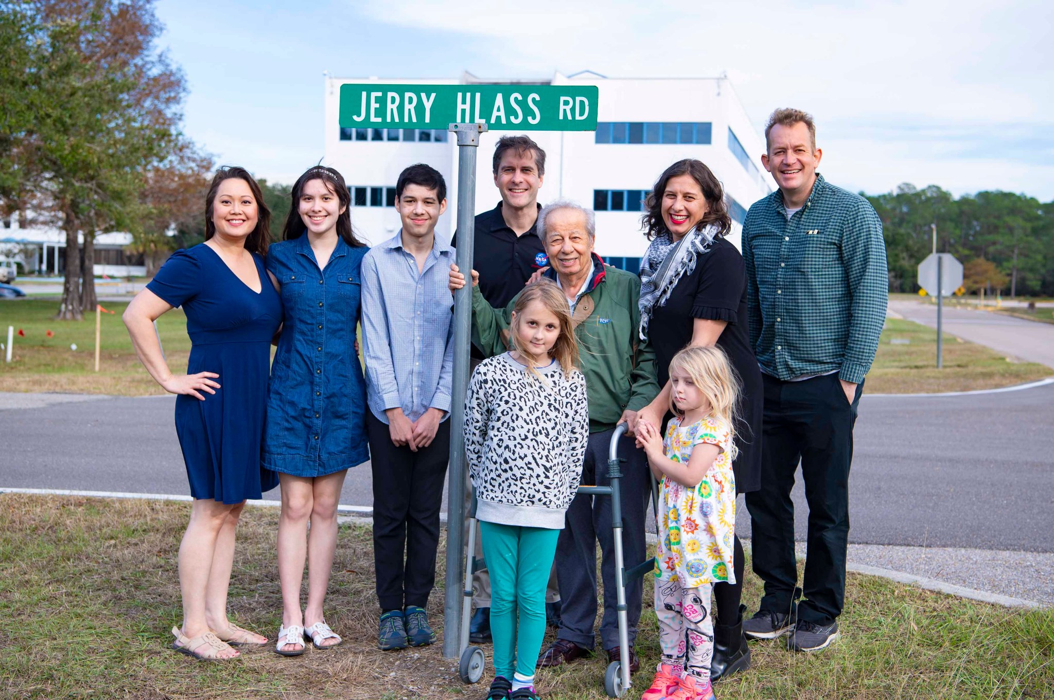 A family standing in front of street sign
