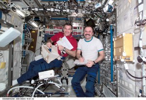 Astronaut James S. Voss (left), Expedition Two flight engineer, unpacks a stowage bag while cosmonaut Yury V. Usachev, Expedition Two mission commander, takes notes in the U.S. Laboratory / Destiny module of the International Space Station (ISS). This image was recorded with a digital still camera.