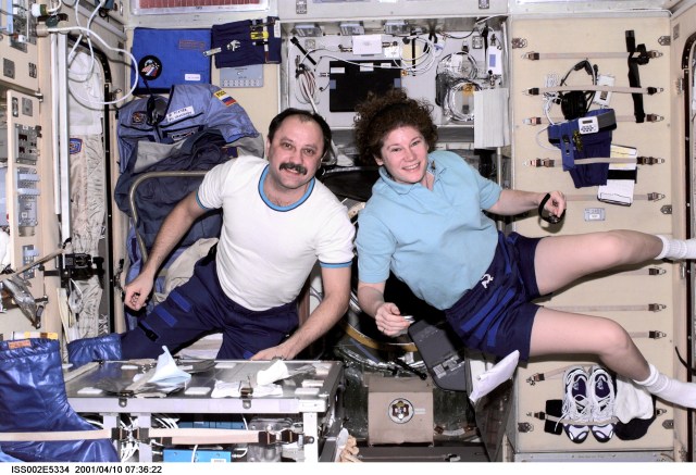 Cosmonaut Yury V. Usachev (left), Expedition Two mission commander, and astronaut Susan J. Helms, Expedition Two flight engineer, pause from their work to pose for a photograph aboard the Zvezda / Service Module of the International Space Station (ISS). This image was recorded with a digital still camera.