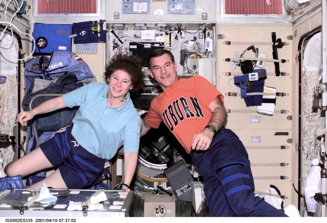Astronaut Susan J. Helms (left and astronaut James S. Voss, both Expedition Two flight engineers, pose for a photograph aboard the Zvezda/Service Module of the International Space Station (ISS). This image was recorded with a digital still camera.