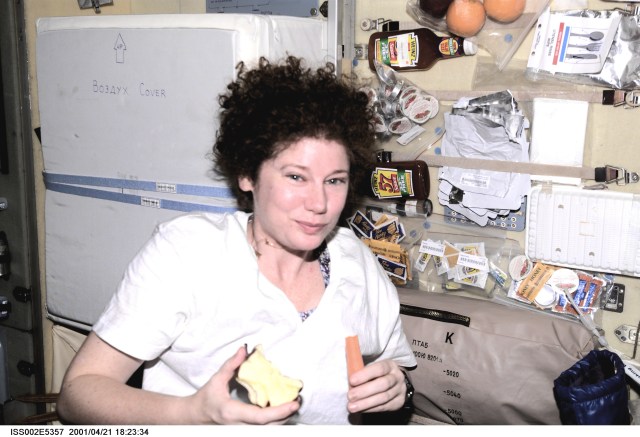 ISS002-E-5357 (21 April 2001) --- Just hours before the arrival of the STS-100/Endeavour crew, astronaut Susan J. Helms, Expedition Two flight engineer, enjoys a brief snack in the Zvezda Service Module on the International Space Station (ISS). The image was recorded with a digital still camera.