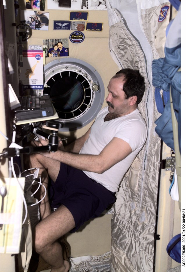 Cosmonaut Yury V. Usachev, Expedition Two mission commander, writes down some notes in his sleeping compartment in the Zvezda / Service Module of the International Space Station (ISS). This image was recorded with a digital still camera.