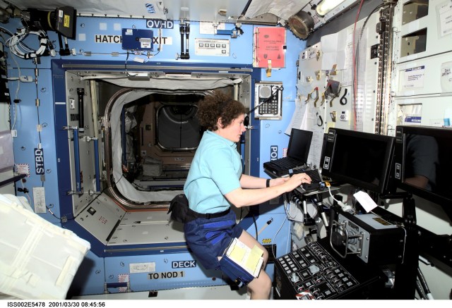 Astronaut Susan J. Helms, Expedition Two flight engineer, works at a laptop computer in the U.S. Destiny laboratory module of the International Space Station (ISS). The Space Station Remote Manipulator System (SSRMS) control panel is visible to Helms' right. This image was recorded with a digital still camera.