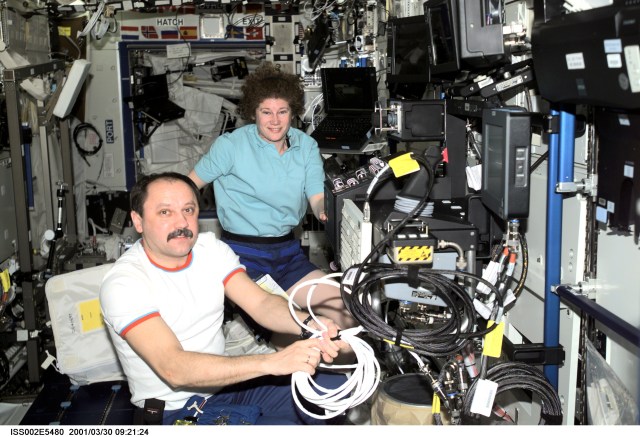 Cosmonaut Yury V. Usachev (foreground), Expedition Two mission commander, and astronaut Susan J. Helms, Expedition Two flight engineer, install cables for the Space Station Remote Manipulator System (SSRMS) or Canadarm2 control panel in preparation for the delivery of the Canadarm2 by the STS-100 crew in April. This image was recorded with a digital still camera.