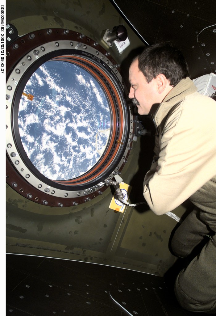 Cosmonaut Yury V. Usachev, Expedition Two mission commander, looks through the window on the Destiny laboratory onboard the International Space Station (ISS). Representing Rosaviakosmos, Usachev is joined by two astronauts on the orbiting outpost for several months' research and work. The photo was taken with a digital still camera.