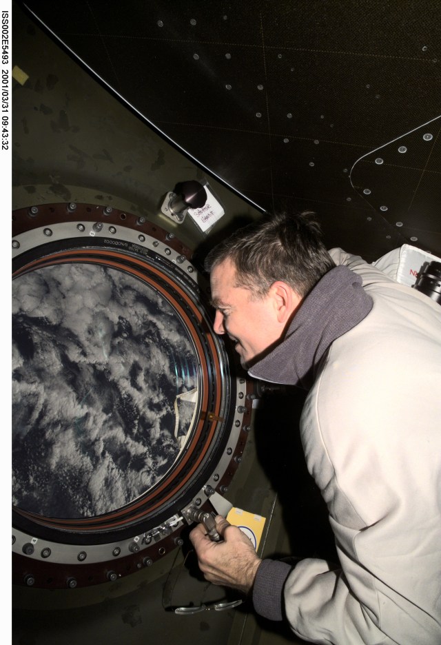 Astronaut James S. Voss, Expedition Two flight engineer, studies the Earth from the very advantageous perspective of the nadir window in the U.S. Destiny laboratory module of the International Space Station (ISS). The image was recorded with a digital still camera.