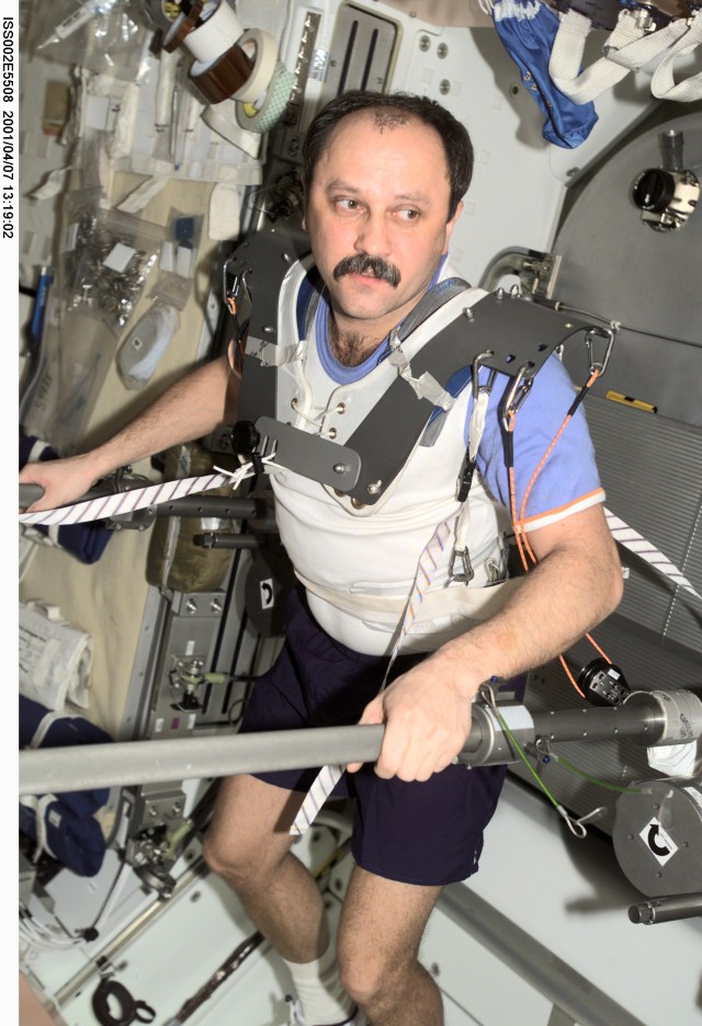 Cosmonaut Yury V. Usachev, Expedition Two commander, wears a harness while conducting resistance exercises in the Unity Node 1 on the International Space Station (ISS). The image was recorded with a digital still camera.