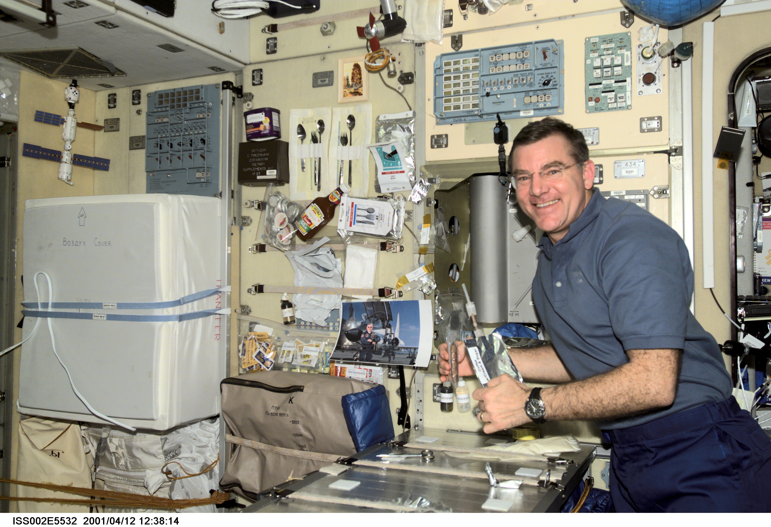 Astronaut James S. Voss, Expedition Two flight engineer, has a coffee and a snack at the table in the Zvezda / Service Module of the International Space Station (ISS). This image was recorded with a digital still camera.