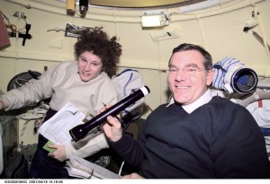 Astronauts Susan J. Helms and James S. Voss, both Expedition Two flight engineers, share a task in the Soyuz spacecraft which is docked to the International Space Station (ISS). The image was recorded with a digital still camera.