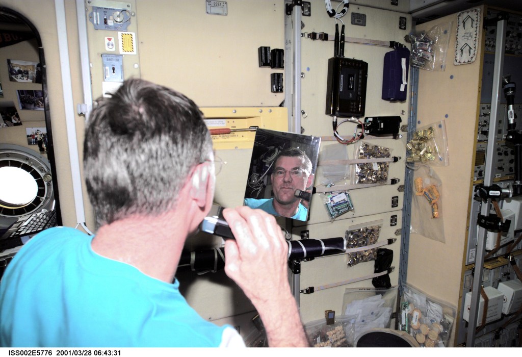 James S. Voss, Expedition Two flight engineer, shaves with an electric razor in the Zvezda Service Module. The image was taken with a digital still camera.