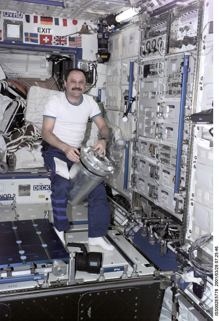 Yury V. Usachev of Rosaviakosmos, Expedtion Two mission commander, works with a Russian water container in the Destiny module. The image was taken with a digital still camera.