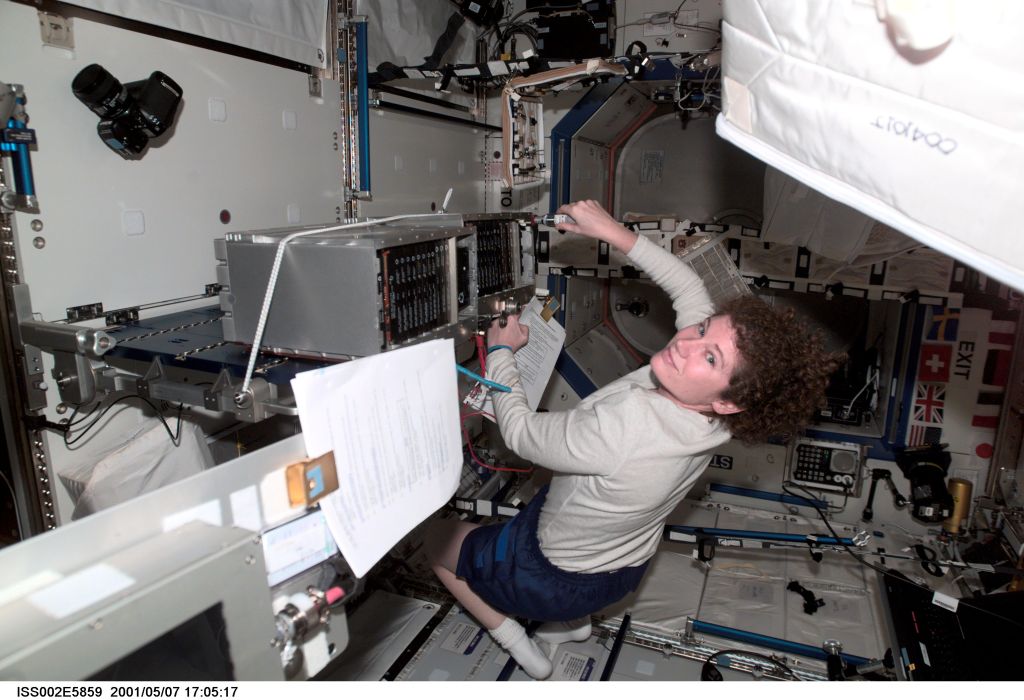 Susan J. Helms, Expedition Two flight engineer, works on an Enhanced Space Station Multiplexer / Demultiplexer (ESSMDM) at the Maintenance Work Assembly (MWA) work surface in the Destiny module. The image was taken with a digital still camera.