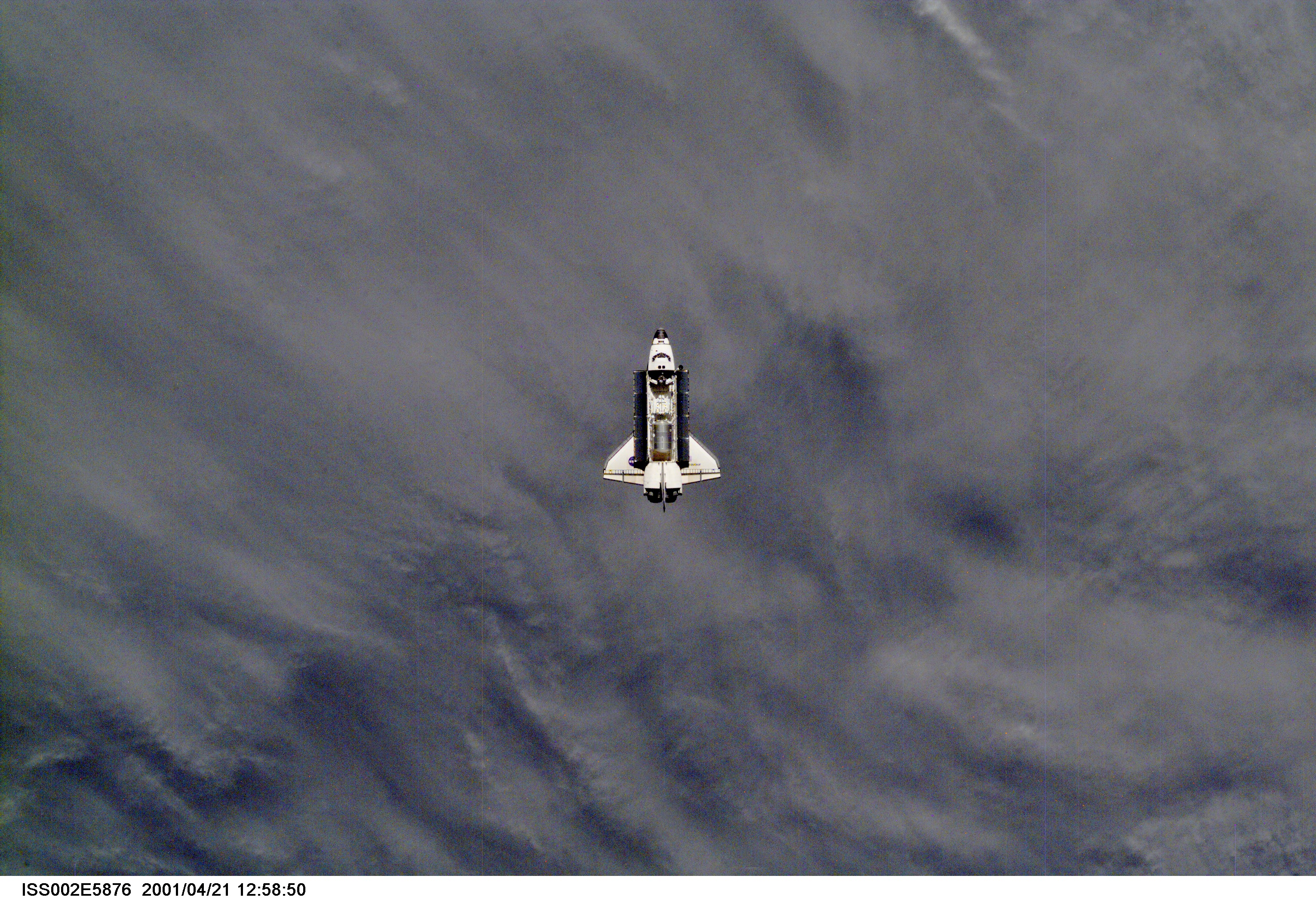 A distant view of the Space Shuttle Endeavour preparing to dock with the International Space Station (ISS) during the STS-100 mission. The STS-100 crewmembers are delivering the Canadarm2, Space Station Remote Manipulator System (SSRMS), and equipment stowed in the Multipurpose Logistics Module (MPLM) Raphaello to the ISS which are visible in Endeavour's payload bay. The image was taken with a digital still camera.
