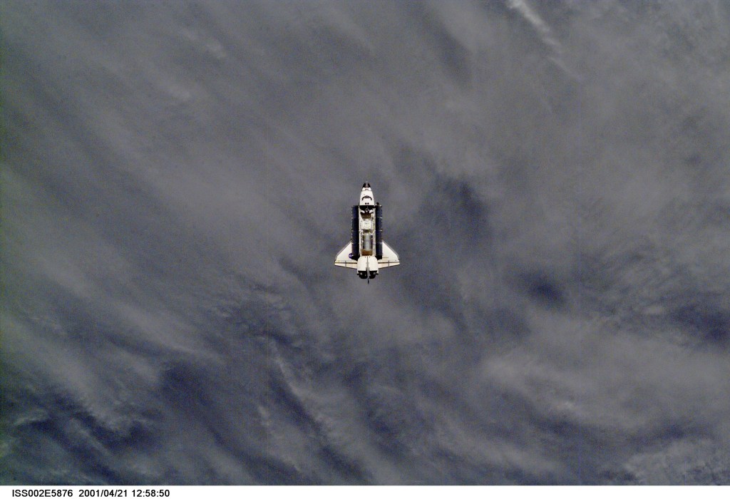 A distant view of the Space Shuttle Endeavour preparing to dock with the International Space Station (ISS) during the STS-100 mission. The STS-100 crewmembers are delivering the Canadarm2, Space Station Remote Manipulator System (SSRMS), and equipment stowed in the Multipurpose Logistics Module (MPLM) Raphaello to the ISS which are visible in Endeavour's payload bay. The image was taken with a digital still camera.