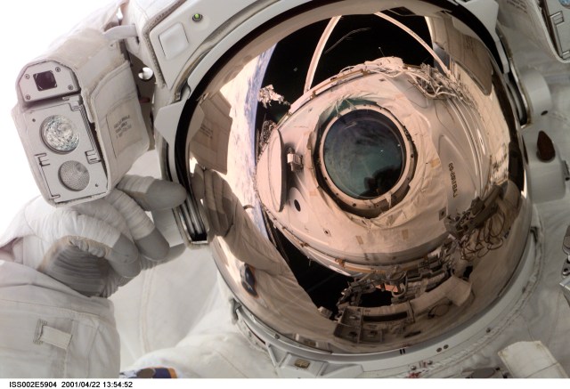 Astronaut Scott E. Parazynski, mission specialist, was photographed with a digital still camera by one of the Expedition Two crew members aboard the International Space Station (ISS) during the first of two scheduled STS-100 space walks. The window on Destiny through which the photo was made is reflected in Parazynski's gold helmet visor. Astronauts Parazynski and Chris A. Hadfield were working to install the Space Station Remote Manipulator System (SSRMS) or Canadarm2 during this extravehicular activity (EVA). Hadfield, representing the Canadian Space Agency (CSA), is reflected in the visor as well.