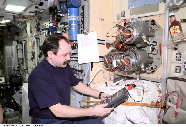 Yury V. Usachev of Rosaviakosmos, Expedition Two mission commander, tests the Vozdukh Air Purification System in the Zvezda Service Module. The image was taken with a digital still camera.