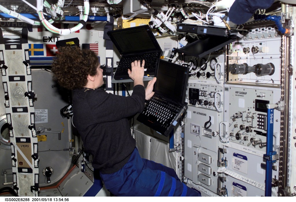 Susan J. Helms, Expedition Two flight engineer, works with three laptop computers at the Human Research Facility (HRF) in the U.S. Laboratory. The image was taken with a digital still camera.