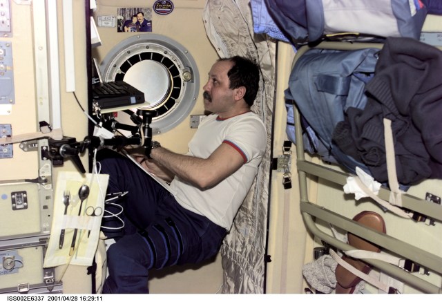Cosmonaut Yury V. Usachev, Expedition Two mission commander, writes down some notes in his sleeping compartment in the Zvezda / Service Module of the International Space Station (ISS). The image was taken with a digital still camera.