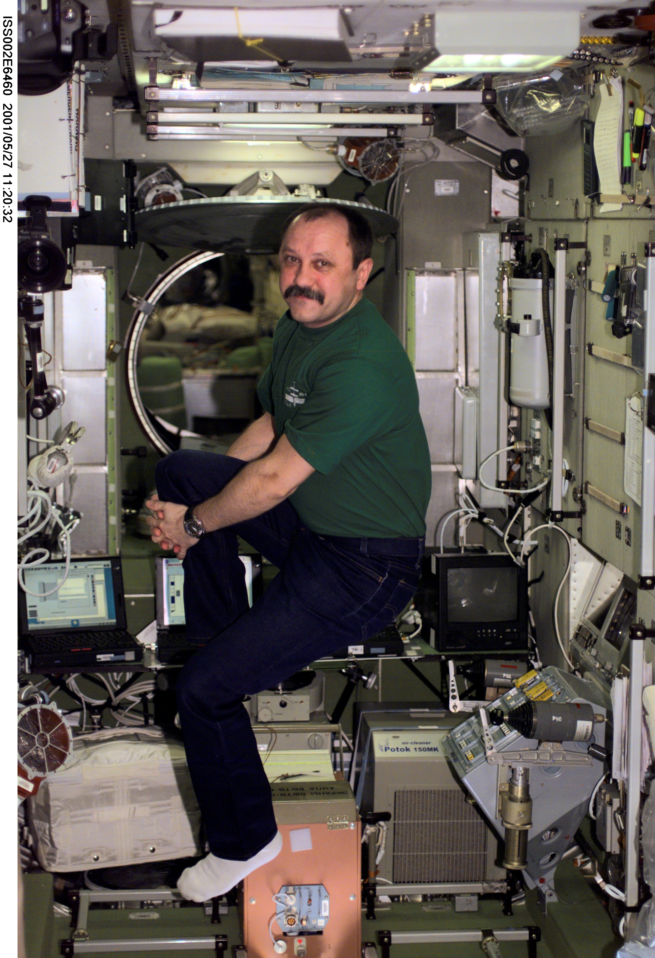 ISS002-E-6460 (27 May 2001) --- Yury V. Usachev of Rosaviakosmos, Expedition Two mission commander, stretches his legs in the Zvezda Service Module. The image was taken with a digital still camera.