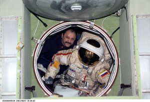 Cosmonaut Yury V. Usachev of Rosaviakosmos, Expedition Two mission commander, moves an Orlan spacesuit through the forward hatch of the Zvezda Service Module. The image was recorded with a digital still camera.