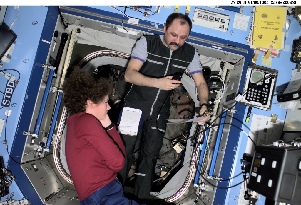Astronaut Susan J. Helms, Expedition Two flight engineer, and cosmonaut Yury V. Usachev, mission commander, discuss a checklist in the Destiny/U.S. Laboratory. Usachev is with Rosaviakosmos. The photo was taken with a digital still camera.