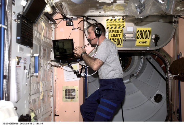 James S. Voss, Expedition Two flight engineer, communicates with Mission Control as he works on a laptop computer in Unity Node 1. The image was taken with a digital still camera.