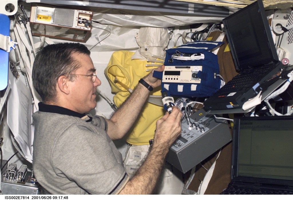 James S. Voss, Expedition Two flight engineer, sets up the Human Research Facility's (HRF) Dosimetric Mapping (DOSMAP) Power Distribution Unit (PDU) in Destiny. The image was taken with a digital still camera.