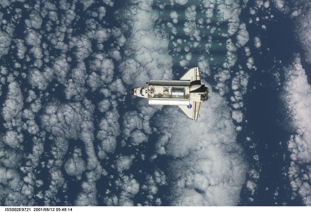 View of the Space Shuttle Discovery as it approaches the International Space Station (ISS) during the STS-105 mission. Aboard Discovery are the members of the Expedition Three crew - Frank L. Culbertson, Jr., mission commander, and cosmonauts Vladimir N. Dezhurov and Mikhail Tyurin, flight engineers - who will be replacing the Expedition Two crew that has been living on the ISS for the past five months. Visible in the payload bay of Discovery are the Multipurpose Logistics Module (MPLM) Leonardo which stores various supplies and experiments to be transferred into the ISS; and the Integrated Cargo Carrier (ICC), which carries the Early Ammonia Servicer (EAS) and two Materials International Space Station Experiment (MISSE) containers. This image was taken with a digital still camera.