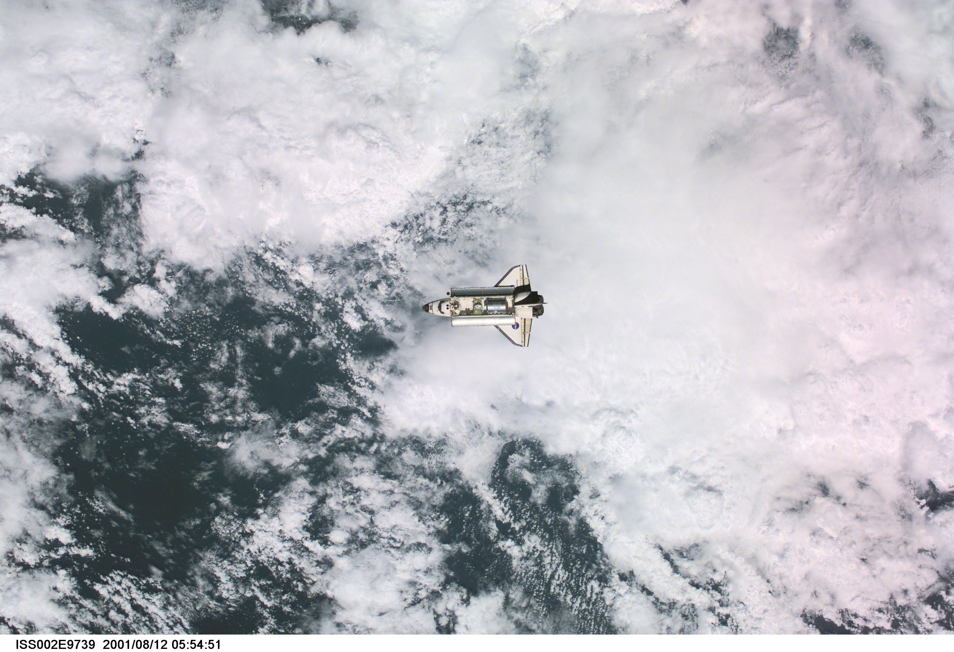 View of the Space Shuttle Discovery as it approaches the International Space Station (ISS) during the STS-105 mission. Aboard Discovery are the members of the Expedition Three crew - Frank L. Culbertson, Jr., mission commander, and cosmonauts Vladimir N. Dezhurov and Mikhail Tyurin, flight engineers - who will be replacing the Expedition Two crew that has been living on the ISS for the past five months. Visible in the payload bay of Discovery are the Multipurpose Logistics Module (MPLM) Leonardo, which stores various supplies and experiments to be transferred into the ISS; and the Integrated Cargo Carrier (ICC), which carries the Early Ammonia Servicer (EAS) and two Materials International Space Station Experiment (MISSE) containers. This image was taken with a digital still camera.