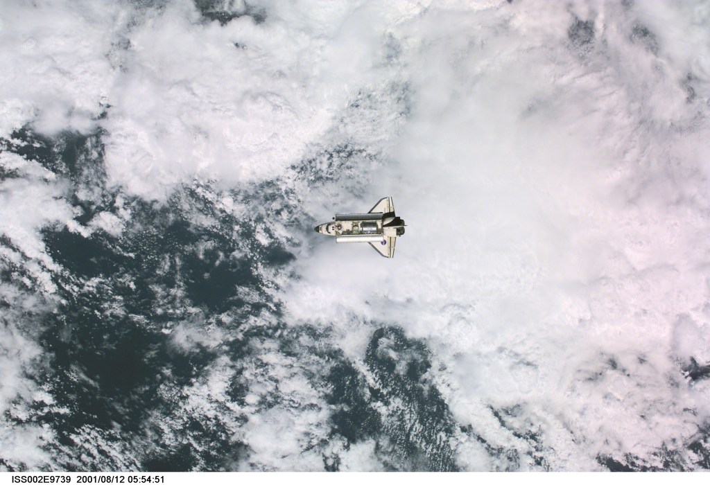 View of the Space Shuttle Discovery as it approaches the International Space Station (ISS) during the STS-105 mission. Aboard Discovery are the members of the Expedition Three crew - Frank L. Culbertson, Jr., mission commander, and cosmonauts Vladimir N. Dezhurov and Mikhail Tyurin, flight engineers - who will be replacing the Expedition Two crew that has been living on the ISS for the past five months. Visible in the payload bay of Discovery are the Multipurpose Logistics Module (MPLM) Leonardo, which stores various supplies and experiments to be transferred into the ISS; and the Integrated Cargo Carrier (ICC), which carries the Early Ammonia Servicer (EAS) and two Materials International Space Station Experiment (MISSE) containers. This image was taken with a digital still camera.